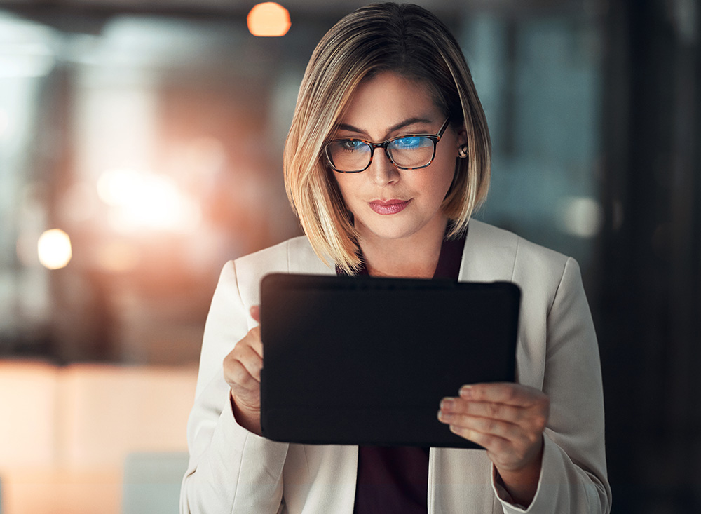 Corporate woman, tablet and working at night in office for company agenda, research and planning. Executive, technology and reading email or report for business results, growth and revenue with data.